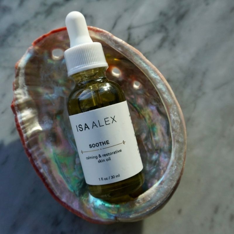 Bottle of ISA ALEX Soothe skin oil with dropper on a shell