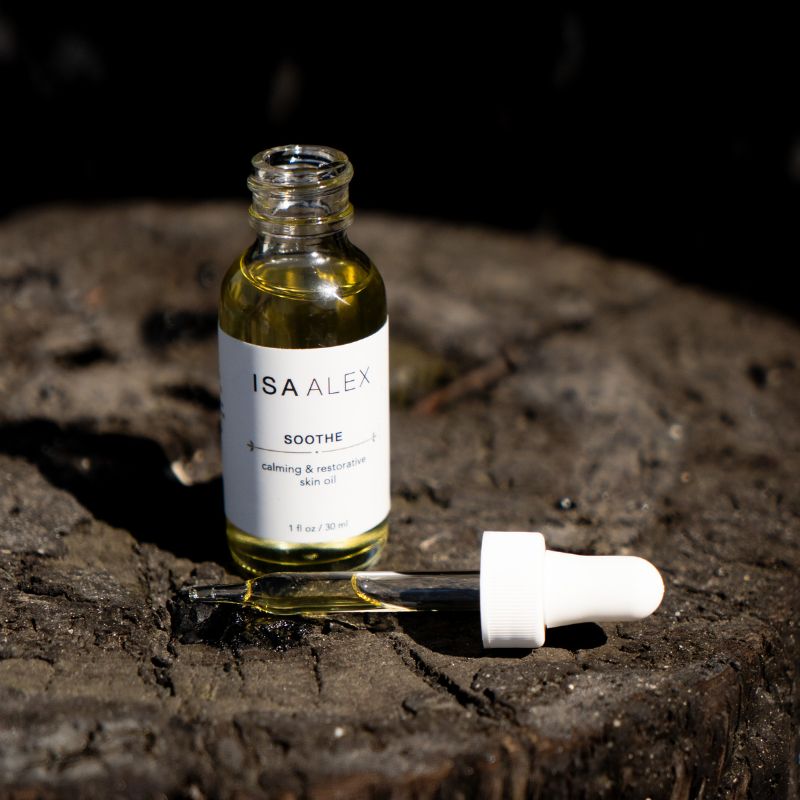 ISA ALEX skincare serum bottle on a wooden surface