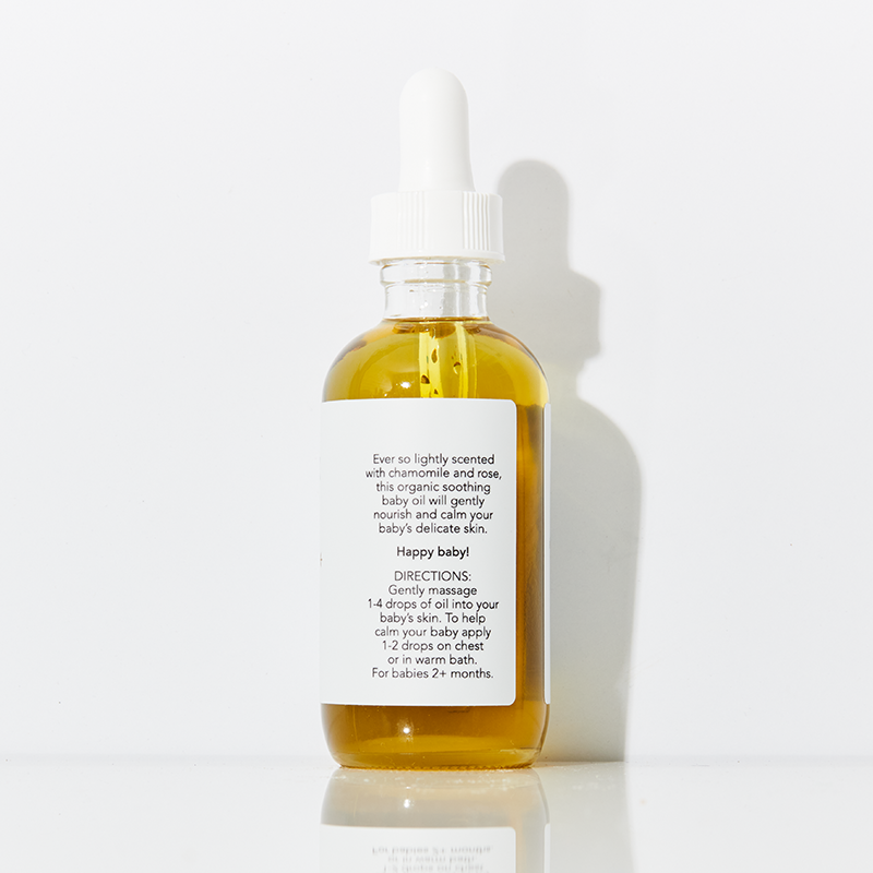 Glass bottle of ISA ALEX baby oil with dropper on a white background